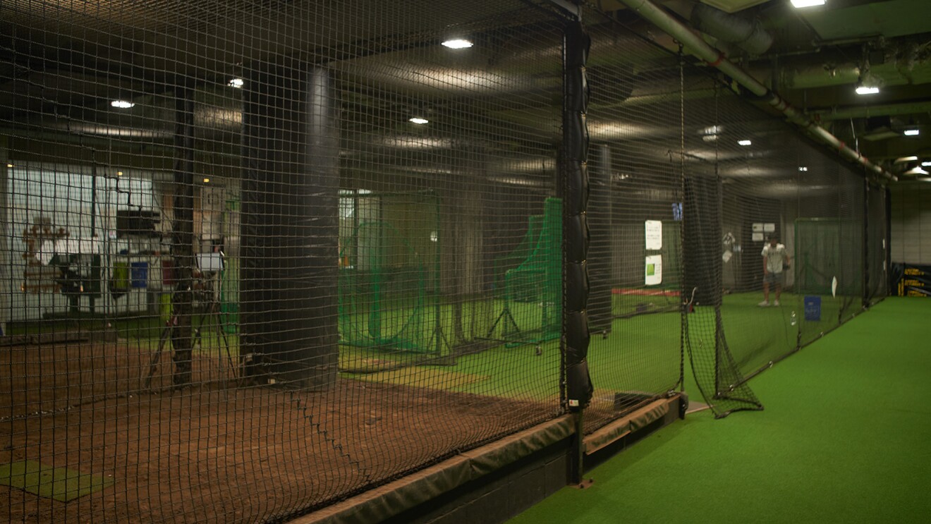 野球の室内練習場。土のマウンドと人工芝のエリアがありネットで区切られている