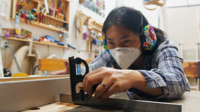 一名妇女在她的工作室里摆弄木头