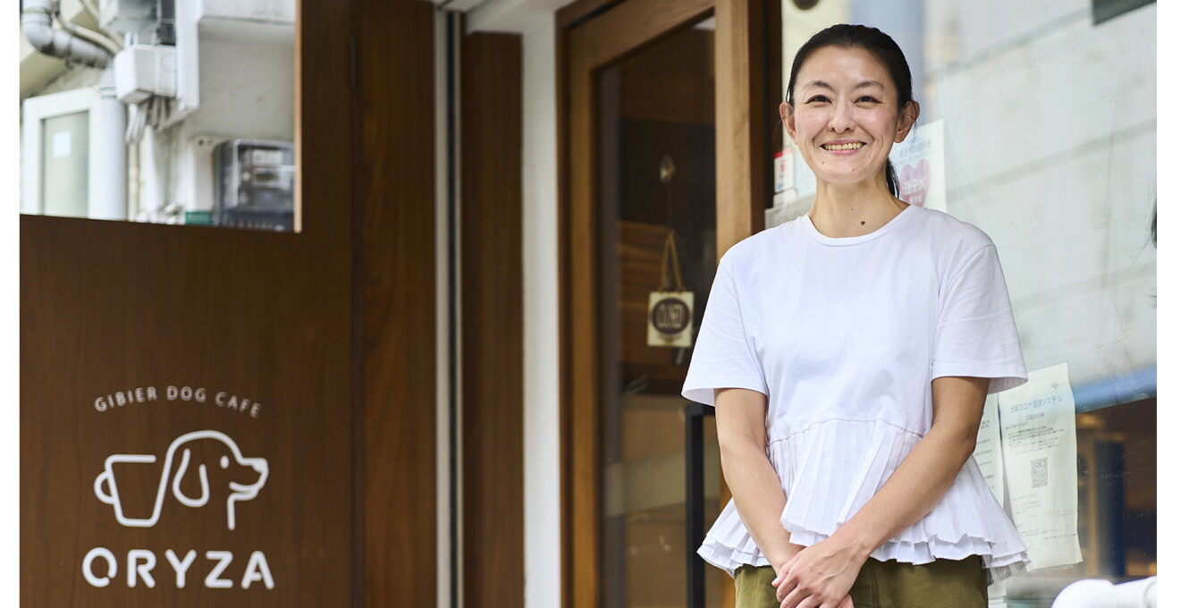 店舗前で笑顔の富田さん