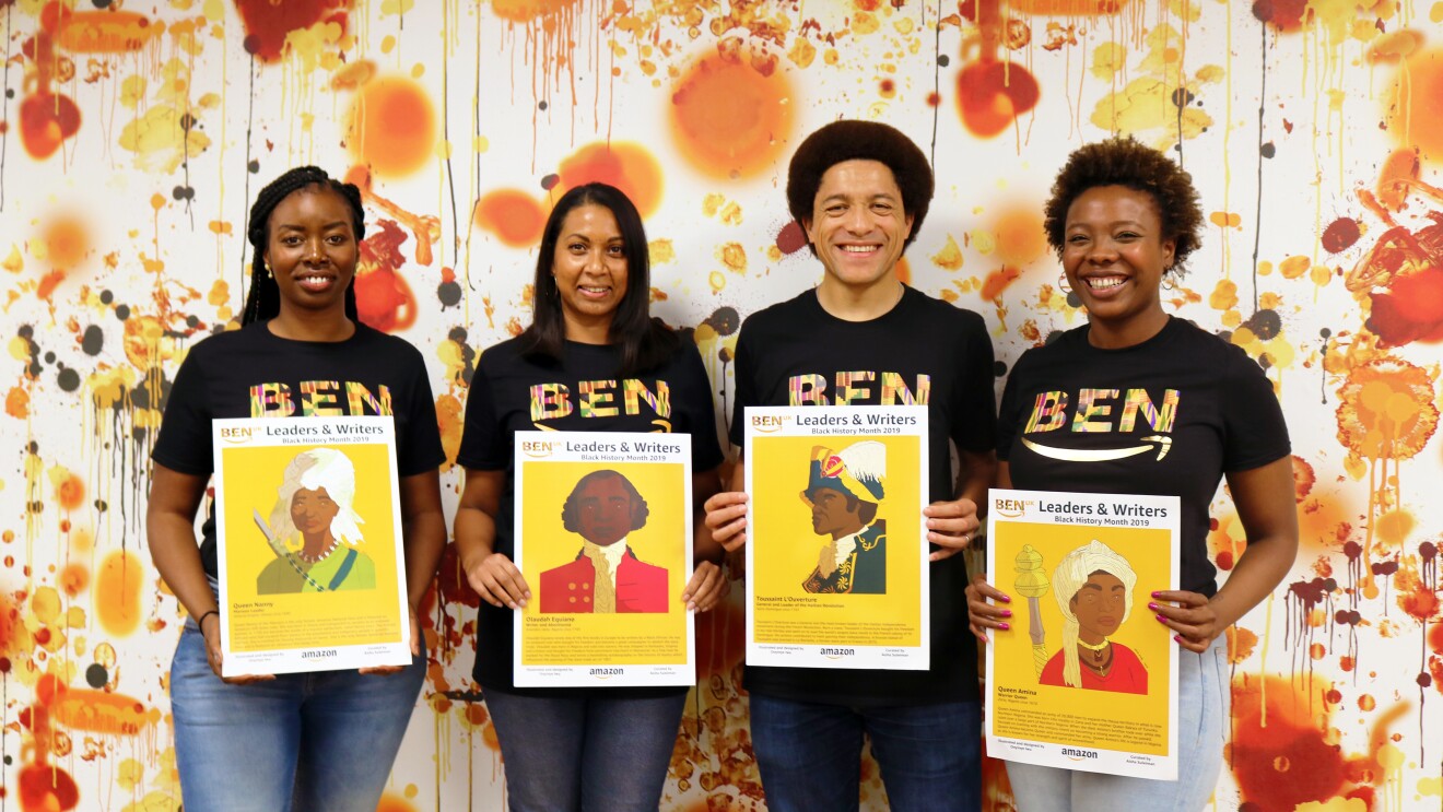 Orange and white group shot of employees holding artwork for BEN
