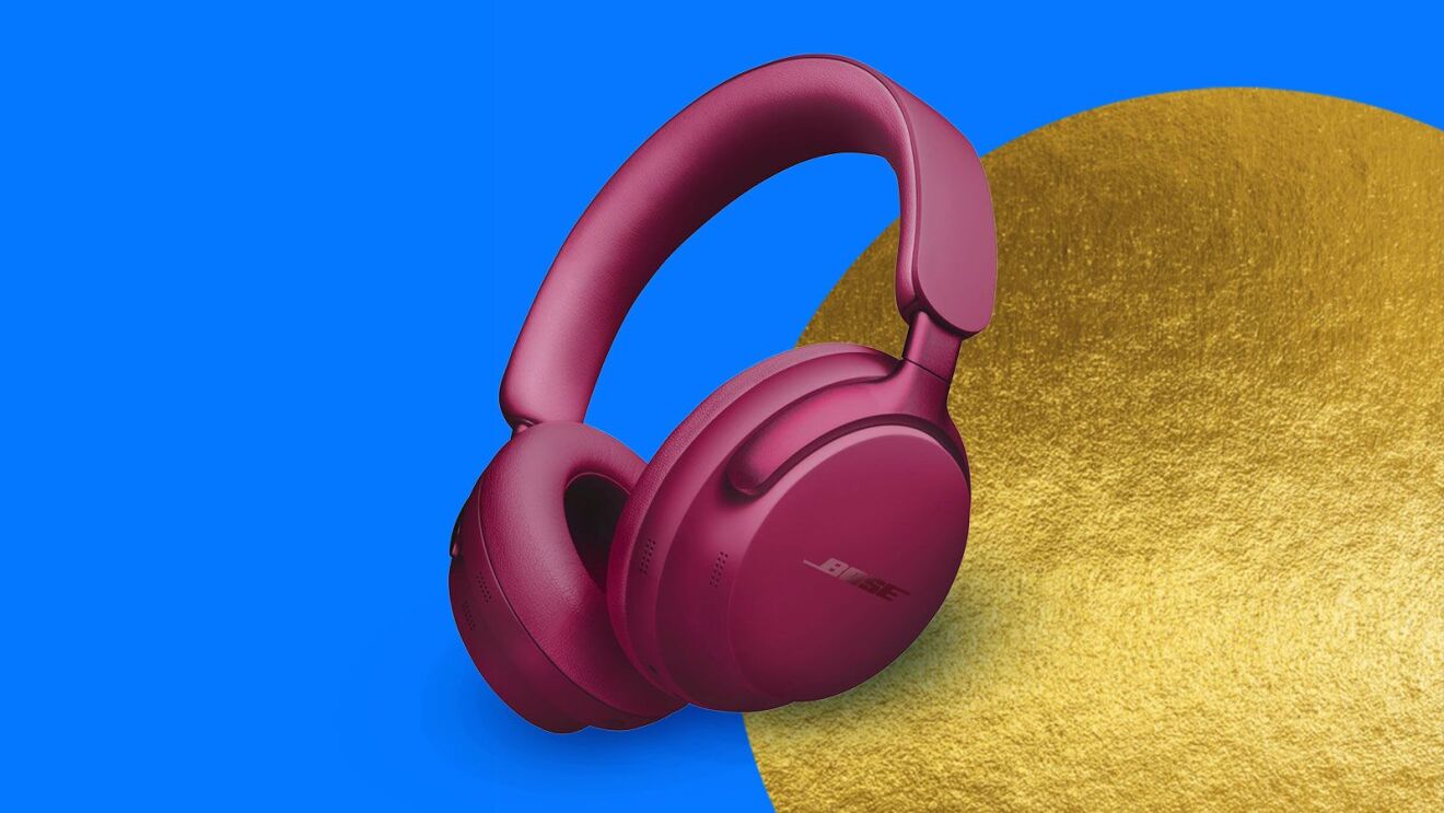 Pink Bose wireless headphones against blue and gold background