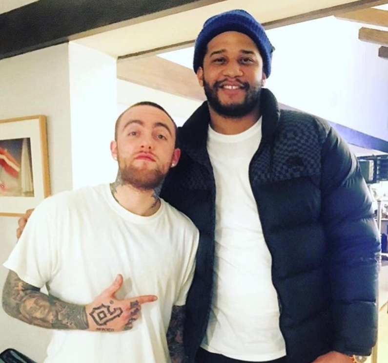 An image of two men smiling for a photo--one is Timothy Hinshaw and one is Mac Miller.