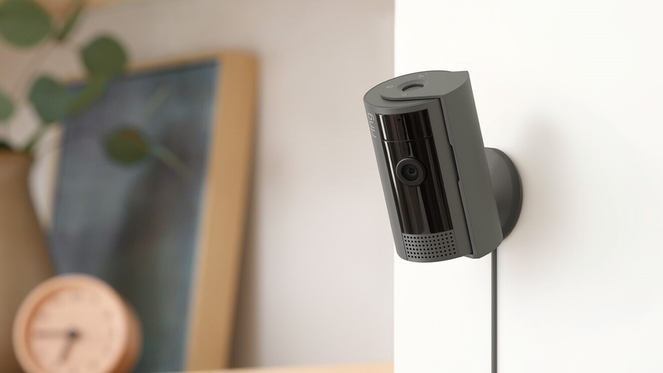 チャコール色のセキュリティカメラがキャビネットの隣にある壁に取り付けられている。