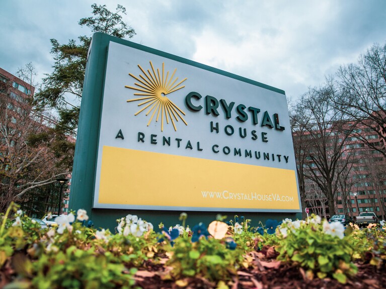 An image of a sign in front of a building that reads "Crystal House: A rental community" with the building's website (www.crystalhouseva.com) at the bottom.