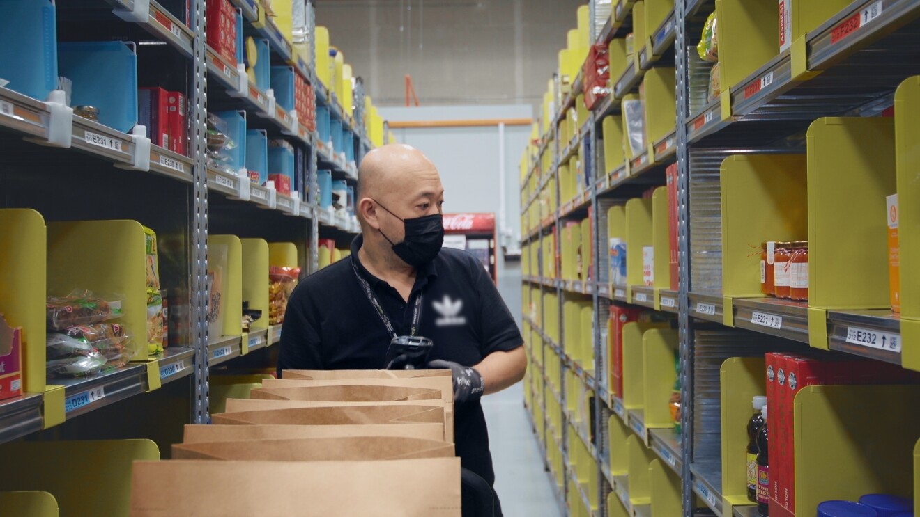 An Amazon associate is seen with a cart of products