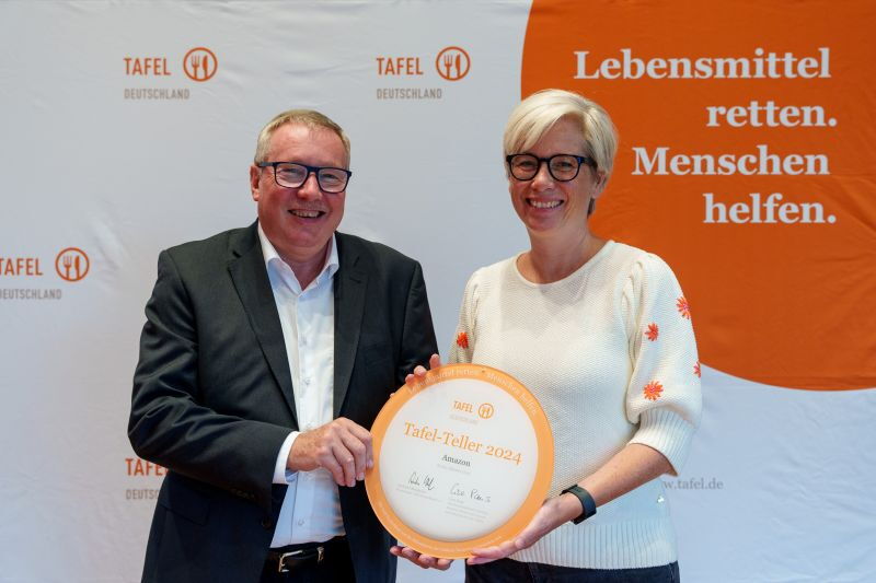 Andreas Steppuhn, Vorsitzender Tafel Deutschland e.V., überreicht den Tafel-Teller an Antje Kurz-Moeller, European Lead for Amazon Community Impact.
