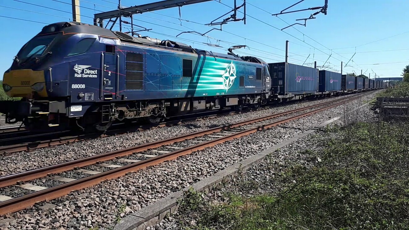 Direct Rail Services locomotive 88008 pulling freight containers on tracks