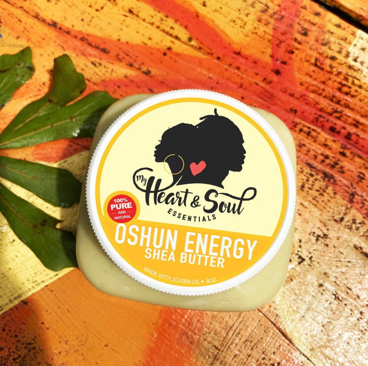 A top-down view of a shea butter product from My Heart and Soul Essentials sits on a wooden table.