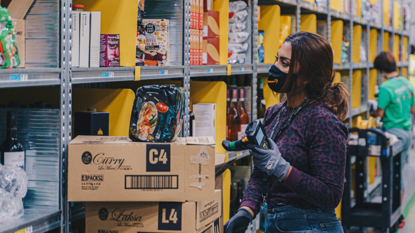 An employee scanning codes to pack products for an Amazon Fresh order