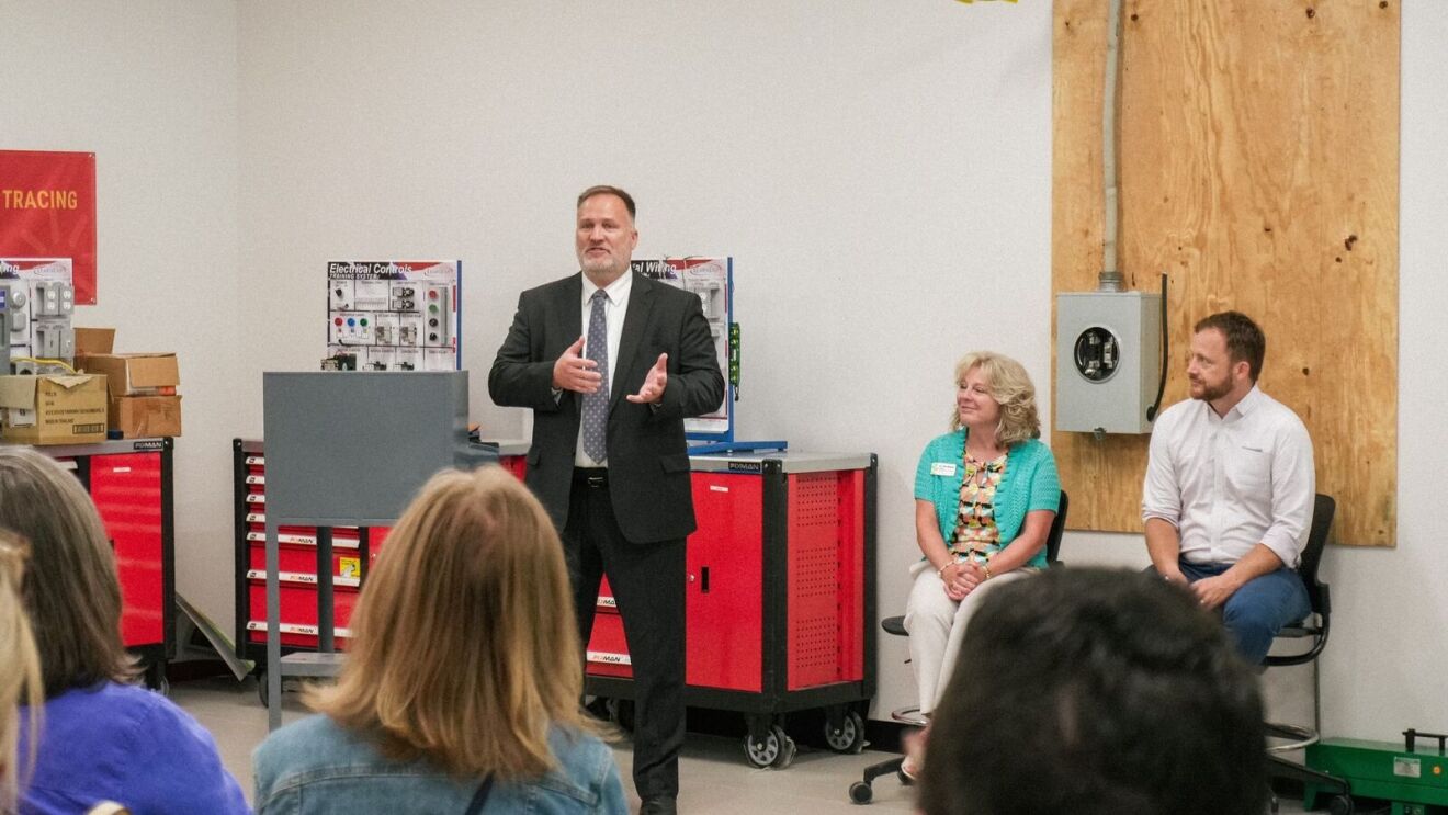 AWS employee addressing small crowd in community college