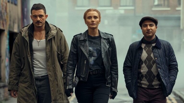 Three diverse individuals in urban streetwear walking confidently down an alley