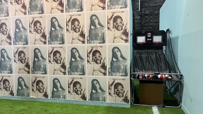 一个房间的图片,绿色的,足球场的地板和蓝色和白色的墙壁,显示安妮塔和2链的照片在墙纸上。