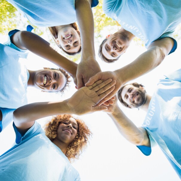 Un groupe de personnes en cercle joignant leurs mains au milieu