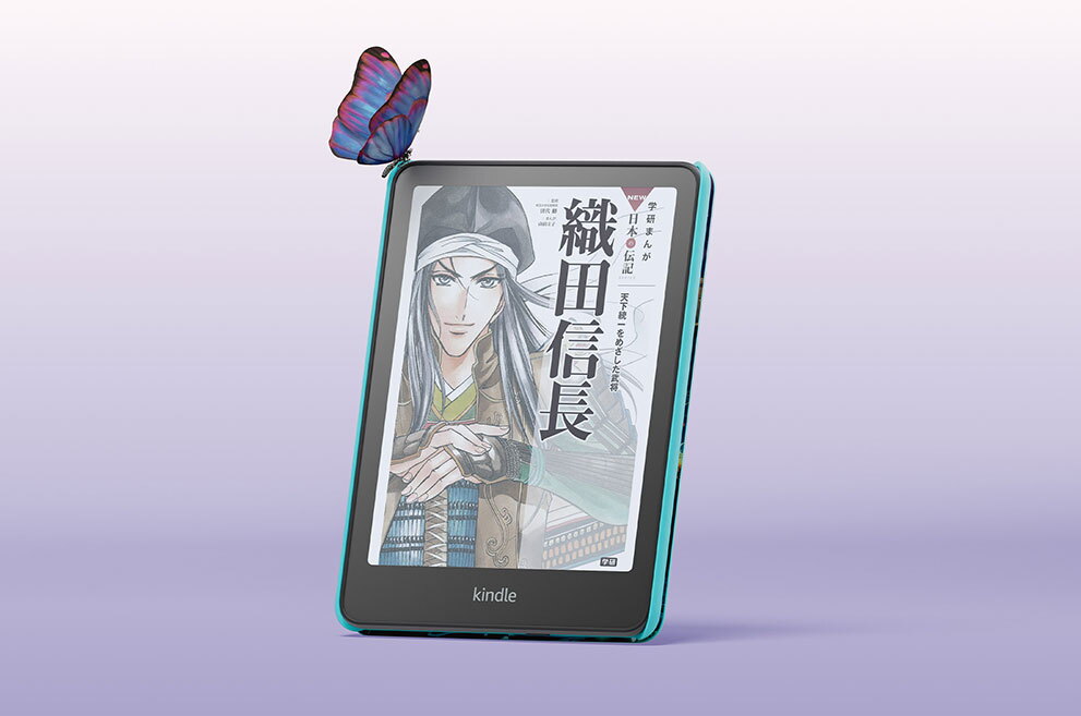 薄紫のグラデーション背景、中央にKindle Colorfosfキッズモデルが置かれている。画面は「織田信長」の書籍表紙で、武士姿のキャラクター絵が見える。端末の左上に蝶がとまっている。