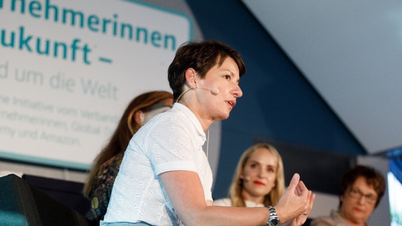VDU-Präsidentin bei einer Podiumsdiskussion von Unterneherminnen der Zukunft. Im Hintergrund sieht man das Logo von Unternehmerinnen der Zukunft sowie die anderen Poduiumsteilnehmerinnen.
