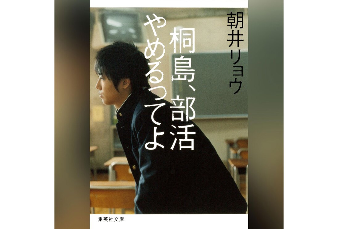 グラデーション背景に、縦長の書籍カバー。教室の黒板、椅子や机を背景に、学生服姿の男子が横を向いて立つ。前面中央に「桐島、部活やめるってよ」の白字。右上隅に「朝井リョウ」の黒字。