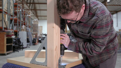 Amazon employee Nico Lovejoy builds a door desk.