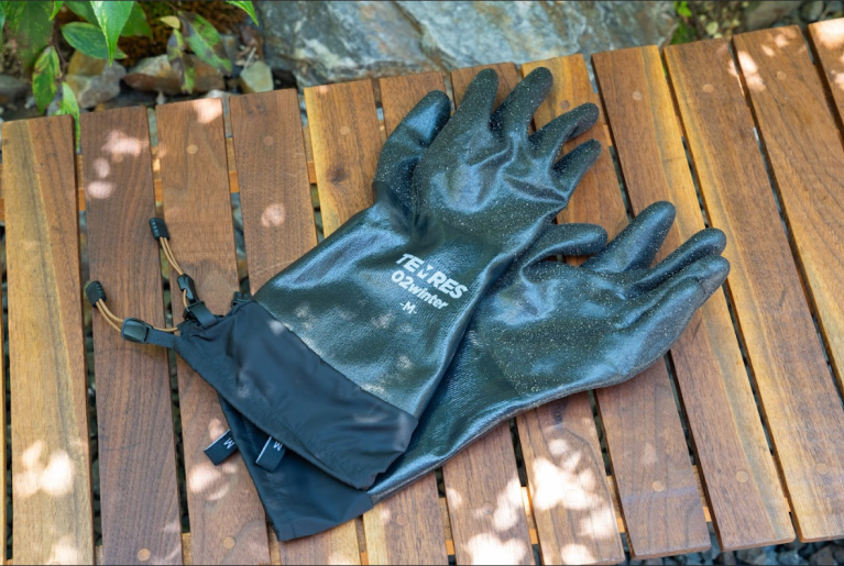 手首のところに紐がついたグリーンのゴム素材の手袋が机の上に置かれている