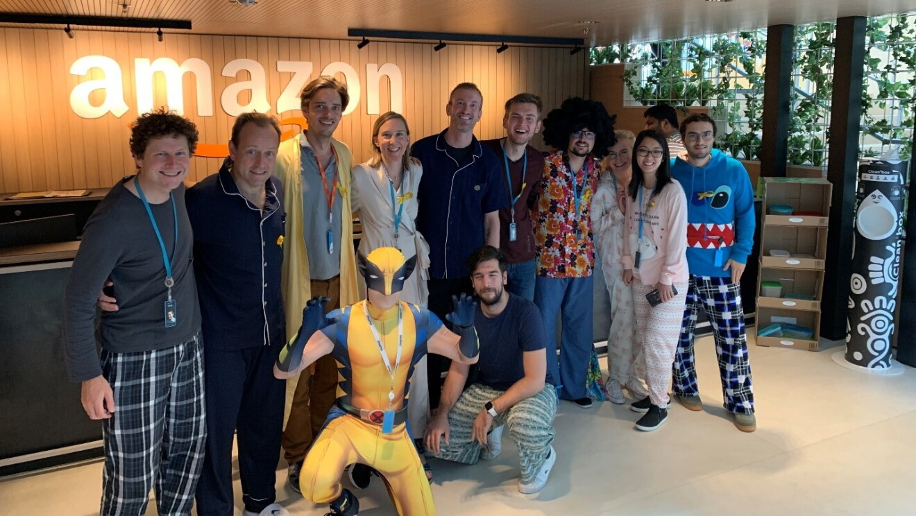 Amazon employees wearing pajamas surrounding our VP Retail Xavier Garambois (second from left) and super hero Wolverine #Pjammin #Letzgogold #deliveringsmile #Childhood cancer awareness.