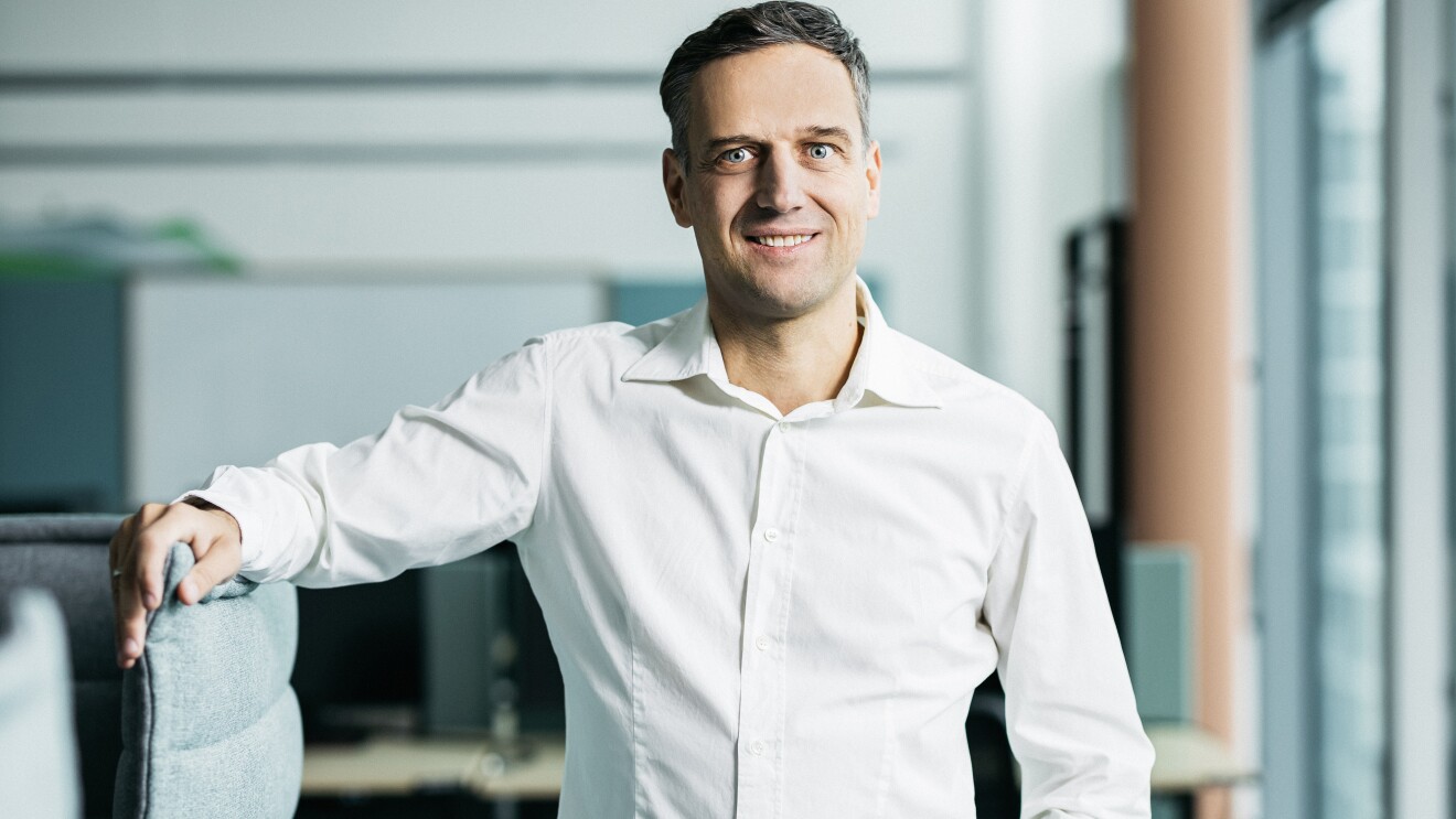 Rocco Bräuniger stehend neben einer Möbelsitzgruppe.