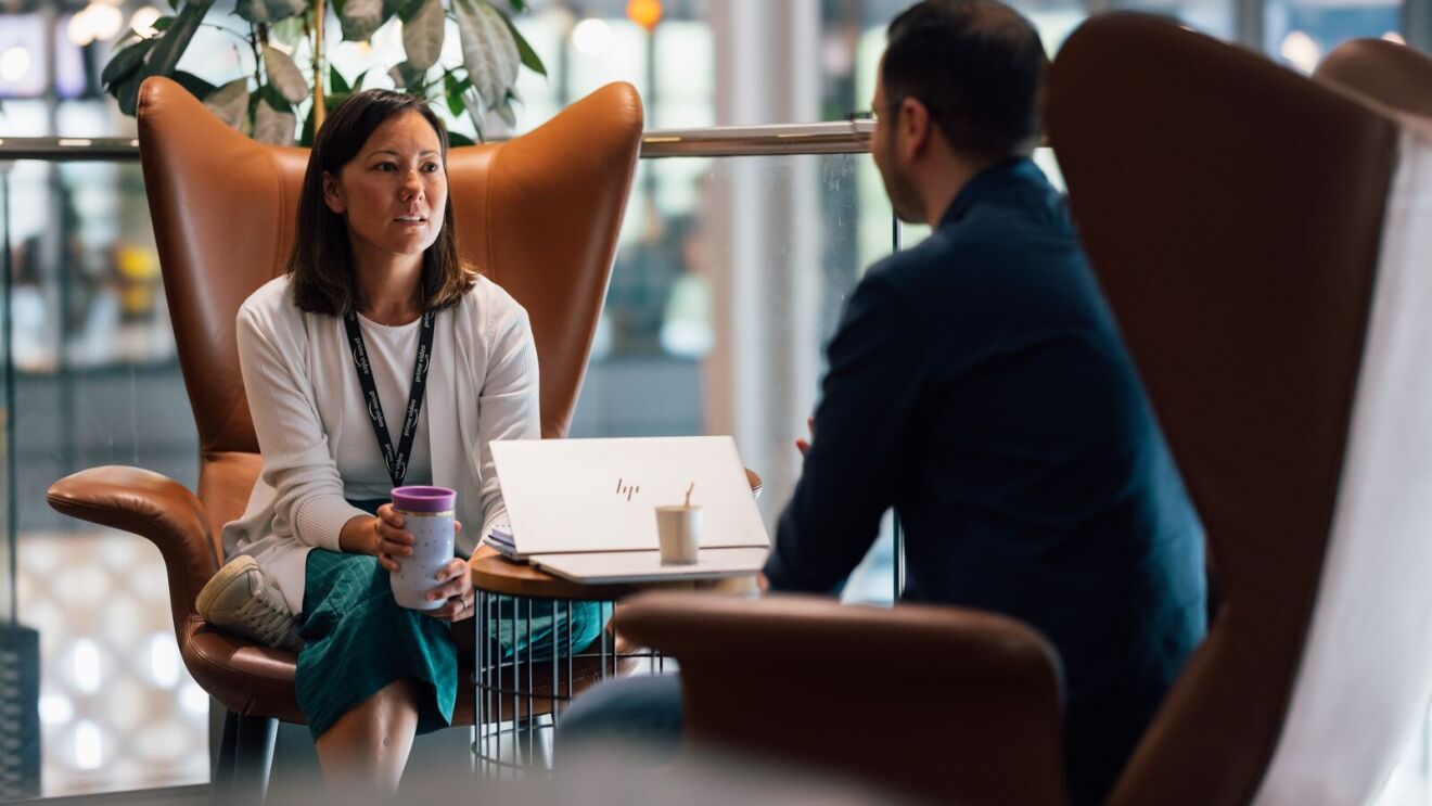 A woman and a man talking while sitting in chairs.
