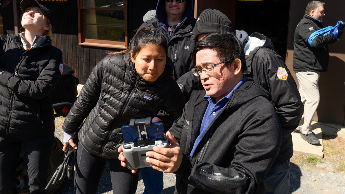 An image of two people looking at a screen on a device and discussing.