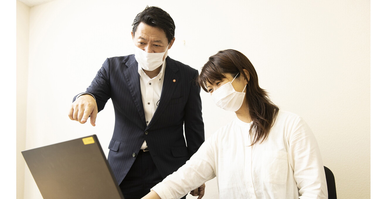 パソコン画面をみながら話し合う滑田さんと職員さん