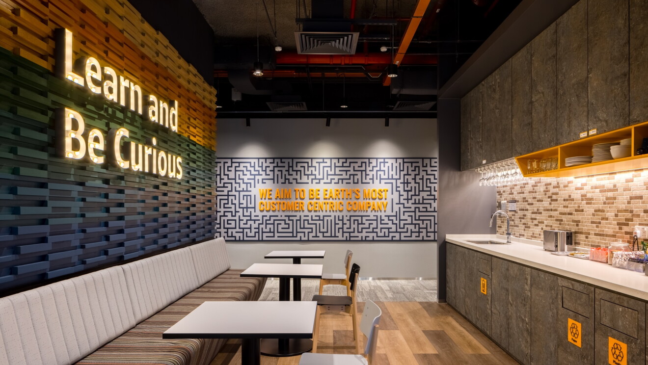 Mini pantry at Sin16 with tables, chairs and a wall with Learn and Be Curious