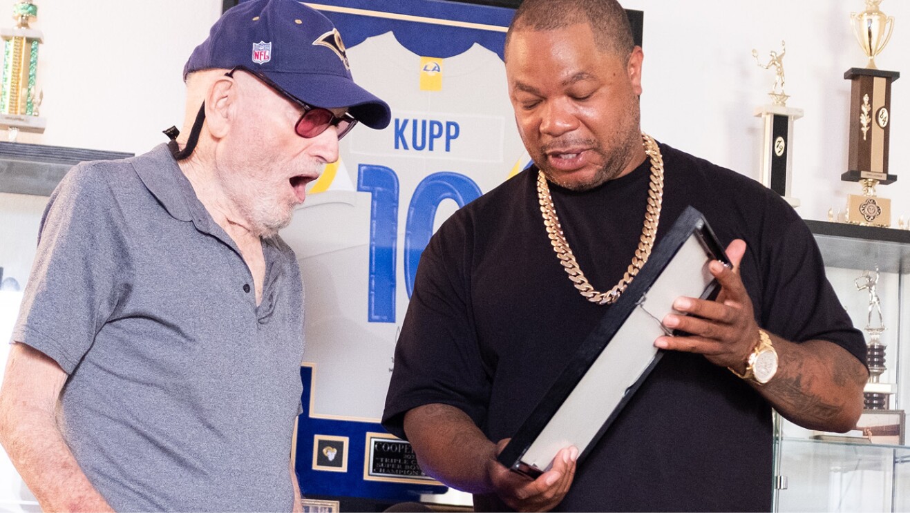 An image of TV personality Xzibit and Lewis Lazarus looking at a frame in Lazarus' new fan cave. 