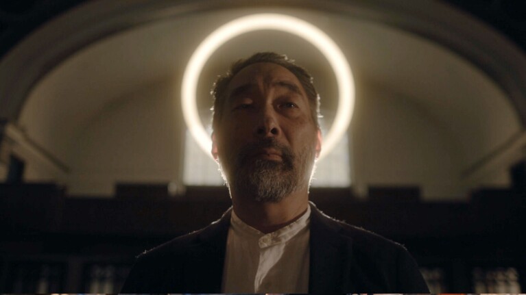 Asian man with a halo above his head inside a church