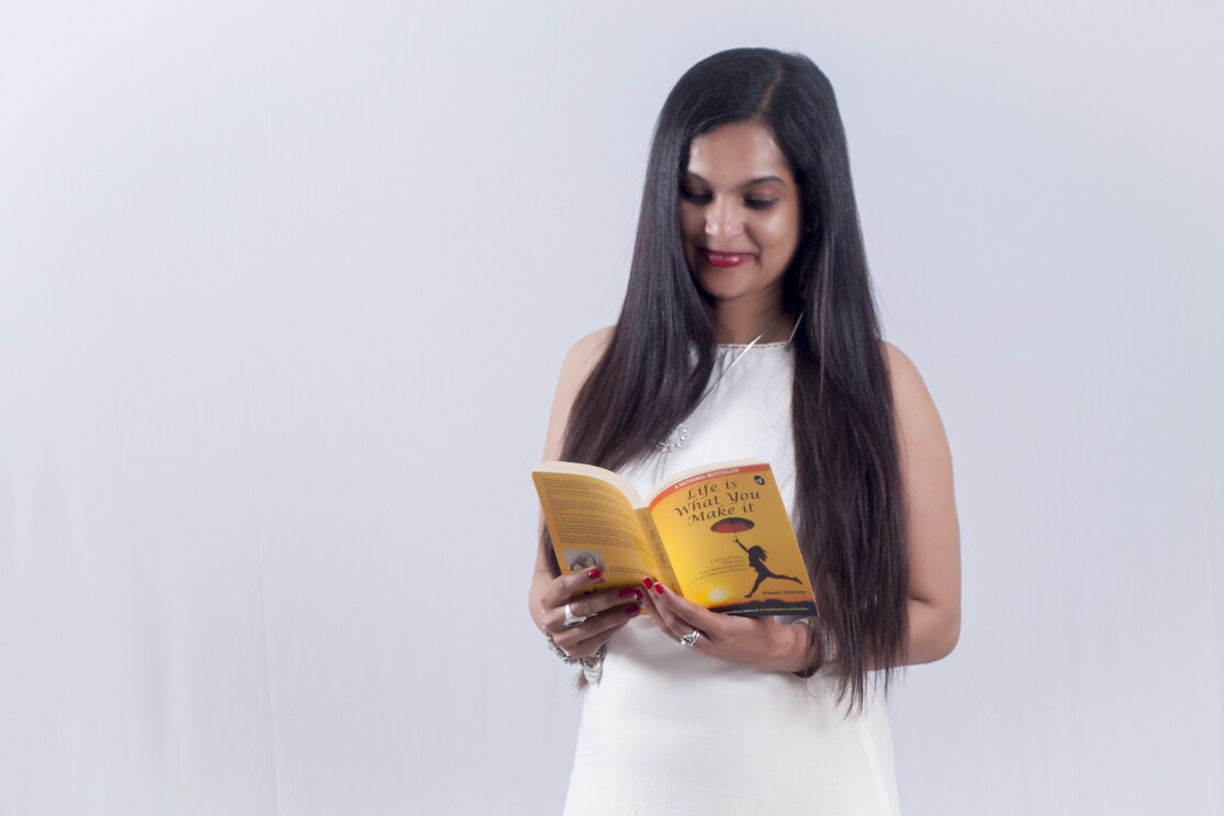 Author Preeti holds a book authored by her and is reading it