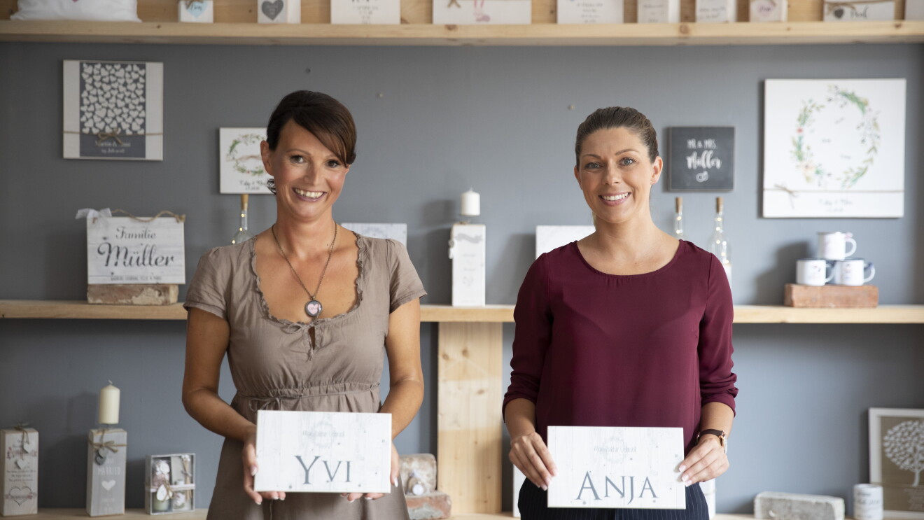 Yivi und Anja von Manufaktur Liebevoll stehen in ihrem Laden und lächeln in die Kamera.