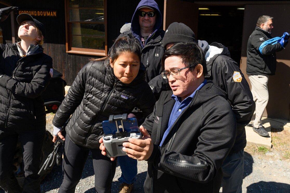 An image of two people looking at a screen on a device and discussing.