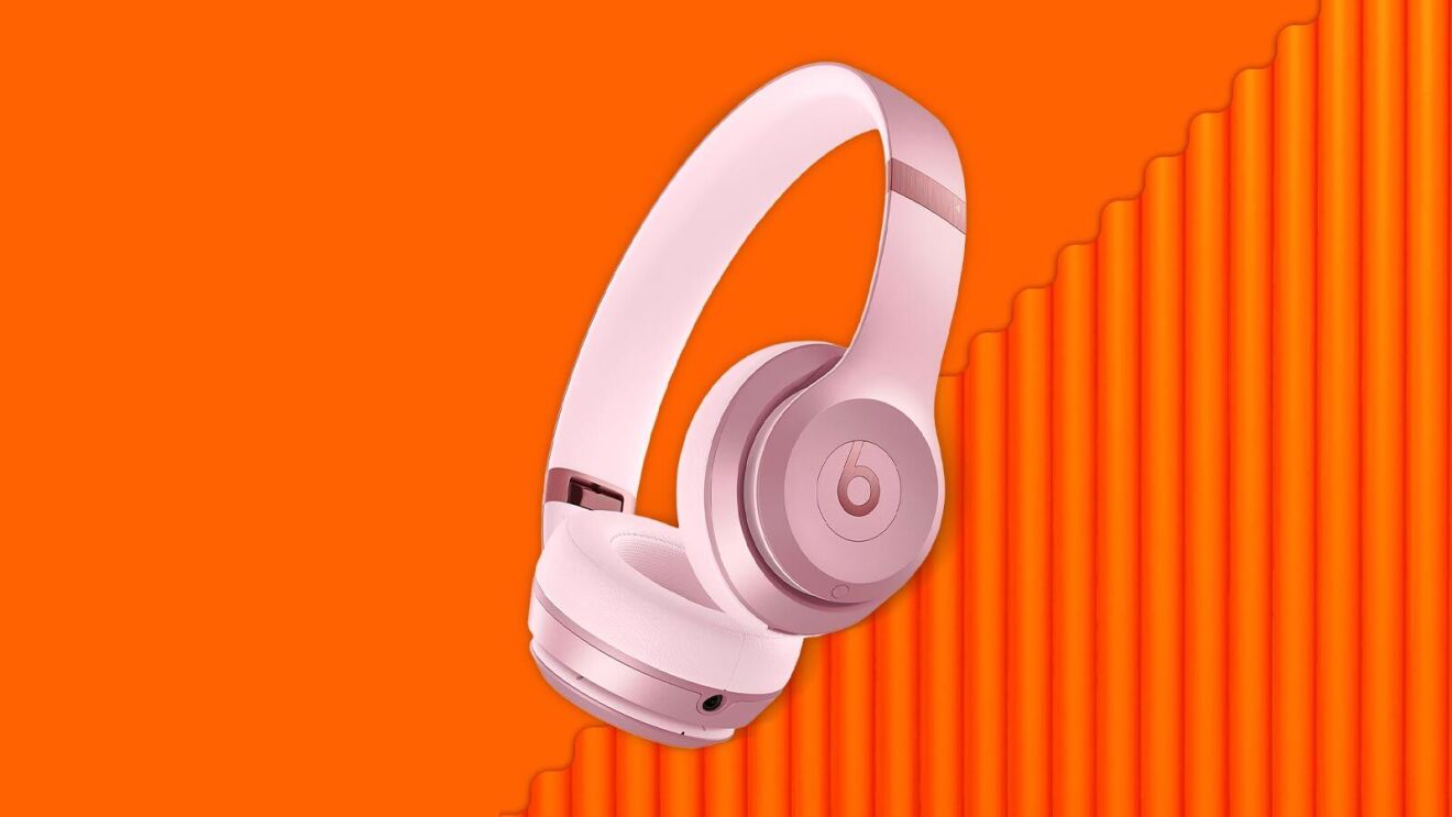 Pink Beats headphones floating against vibrant orange background