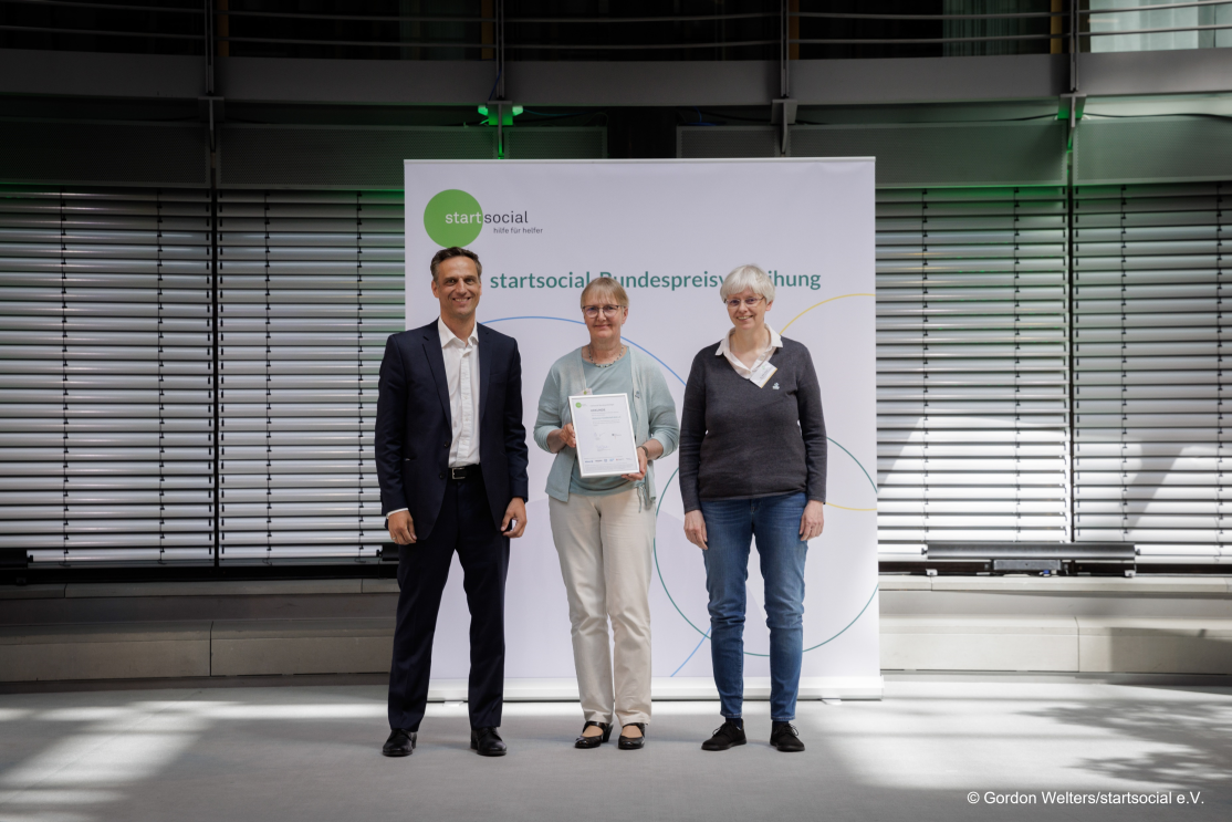 Rocco Bräuniger, Amazon.de Country Manager, überreicht einen startsocial-Preis an Alzheimer Gesellschaft Kiel e.V., vertreten durch Dr. Silke Kraus und Marion Karstens. 
