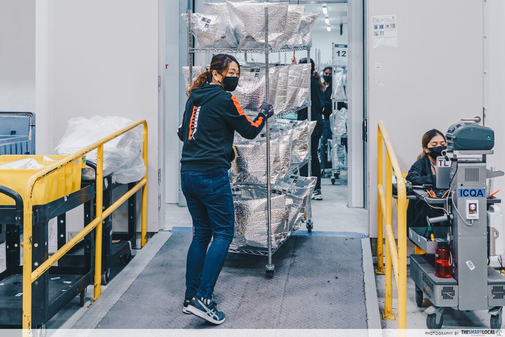 An employee wheeling a cart from the chiller filled at the Amazon Fresh fulfillment centre