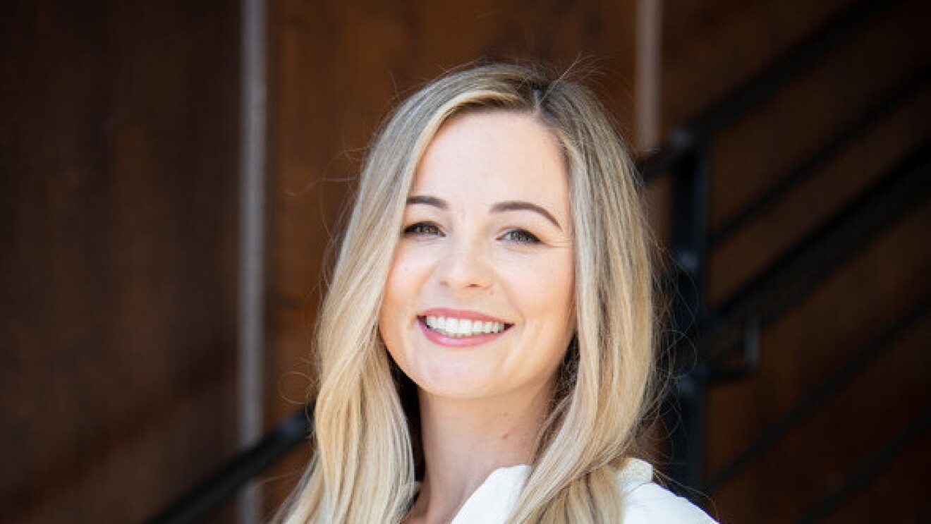 A headshot of Courtney Jones, CEO and founder of the ClearTheList Foundation and #ClearTheList, smiling against a black background.