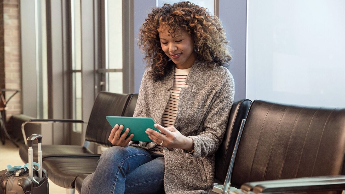 Woman holding an Amazon Fire tablet in airport