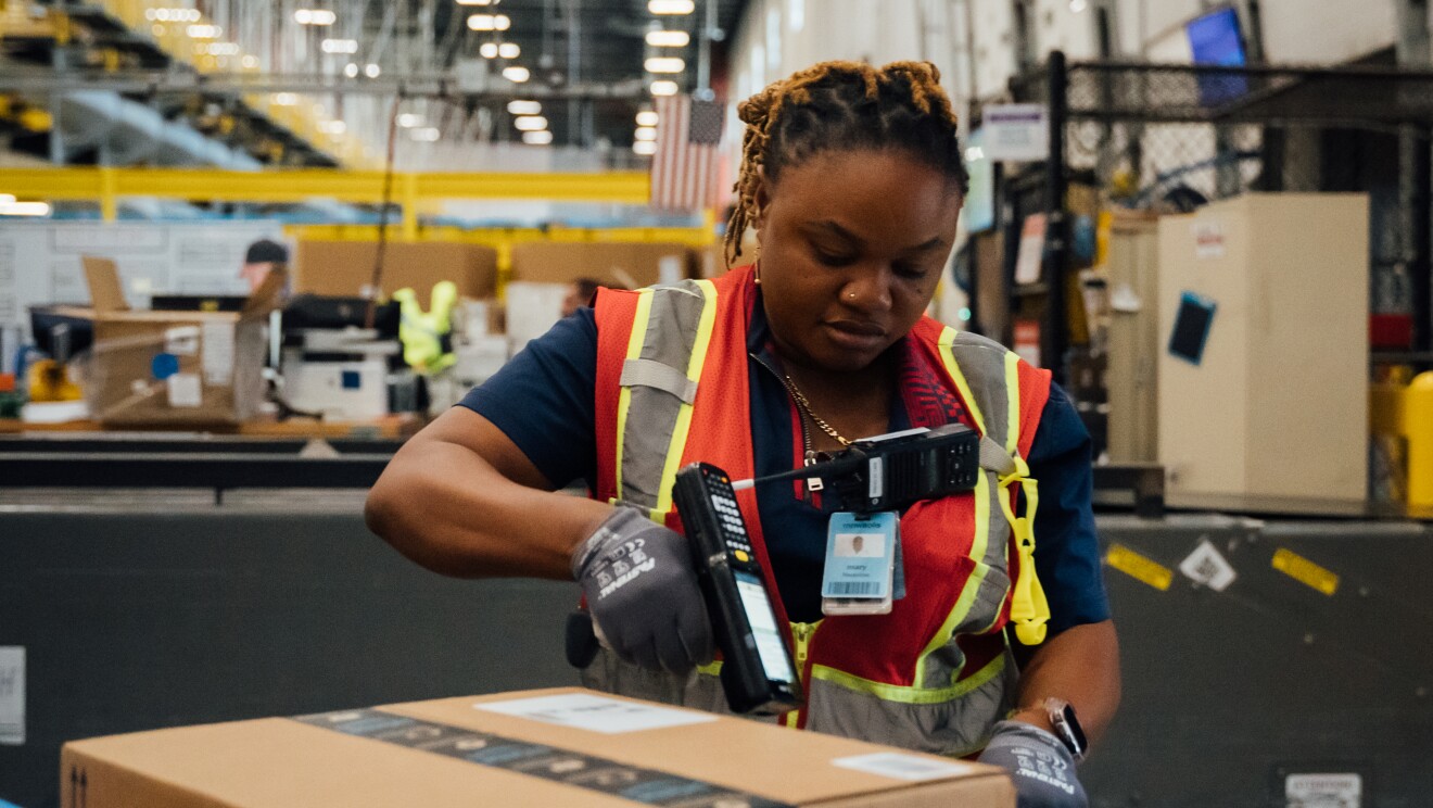 Un employé d'Amazon emballant un produit