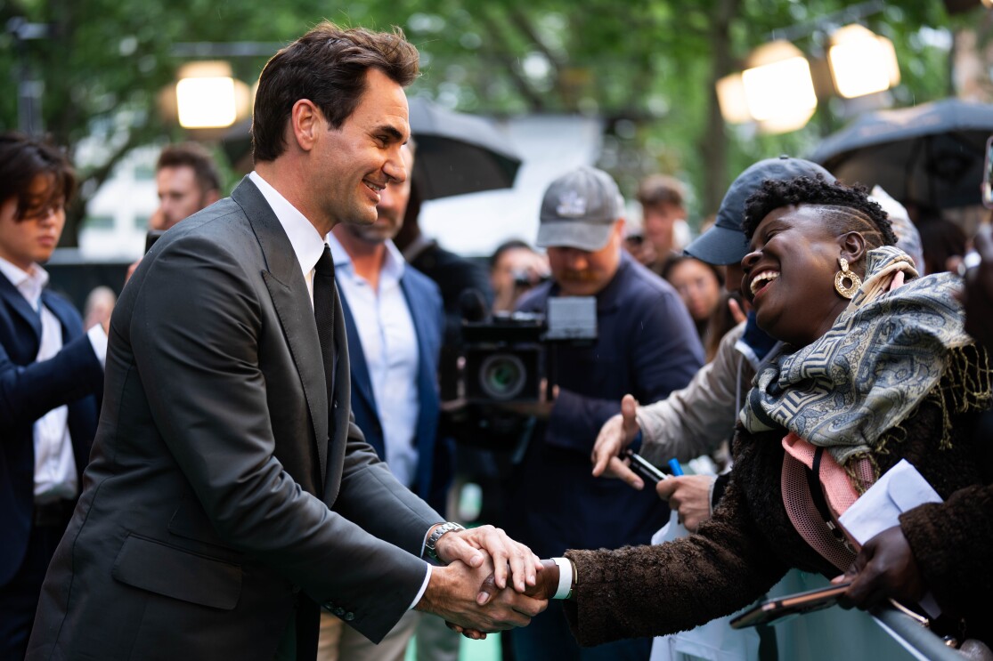 Tennis star Roger Federer meeting fans and holding hands with them