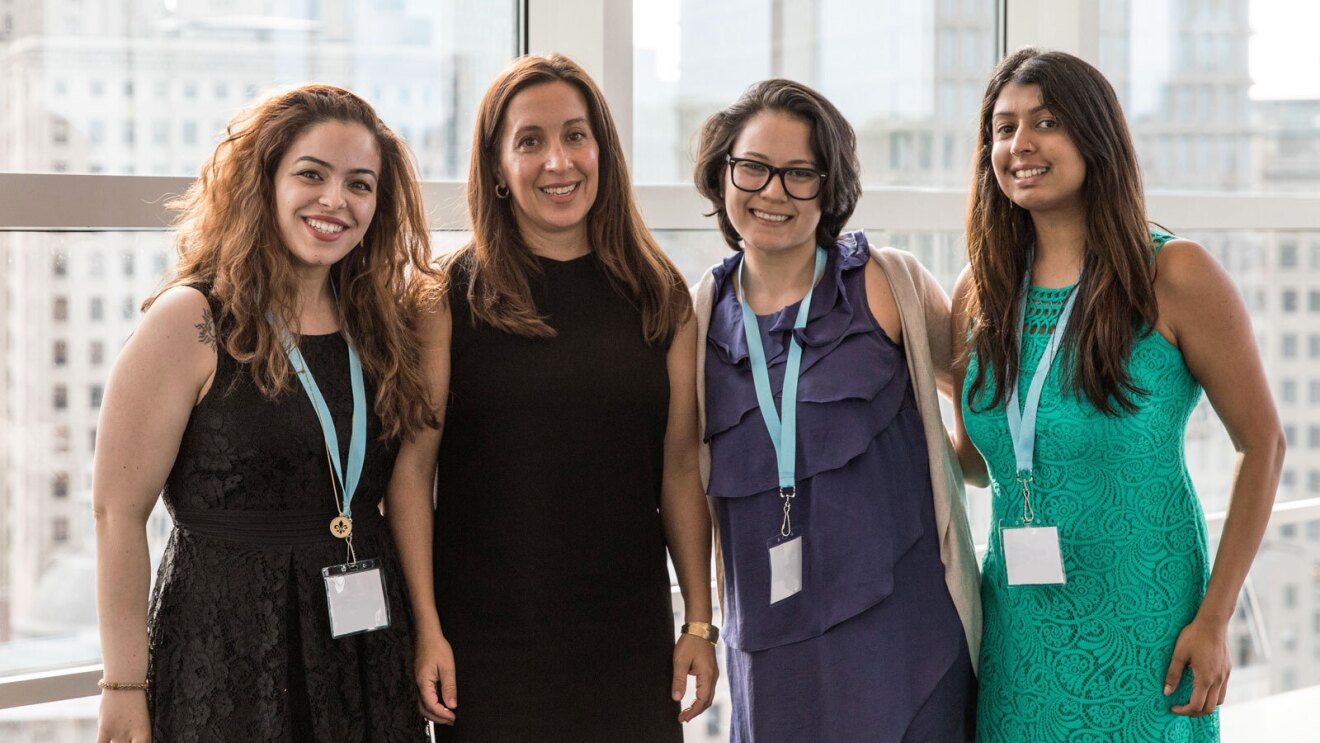 Justine Hastings smiles and stands next to three other woman.