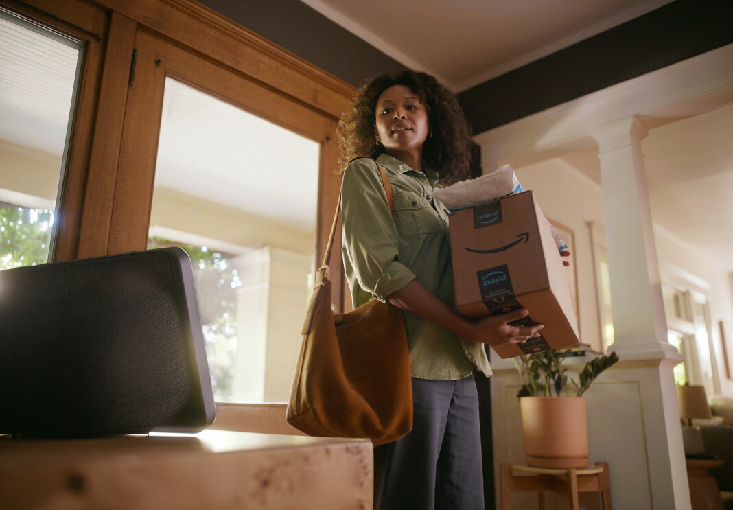 women hold amazon packing and looking at Alexa+ device
