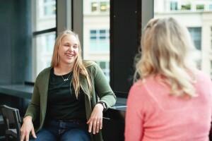 Two woman engage in a conversation with each other in an Amazon office. 