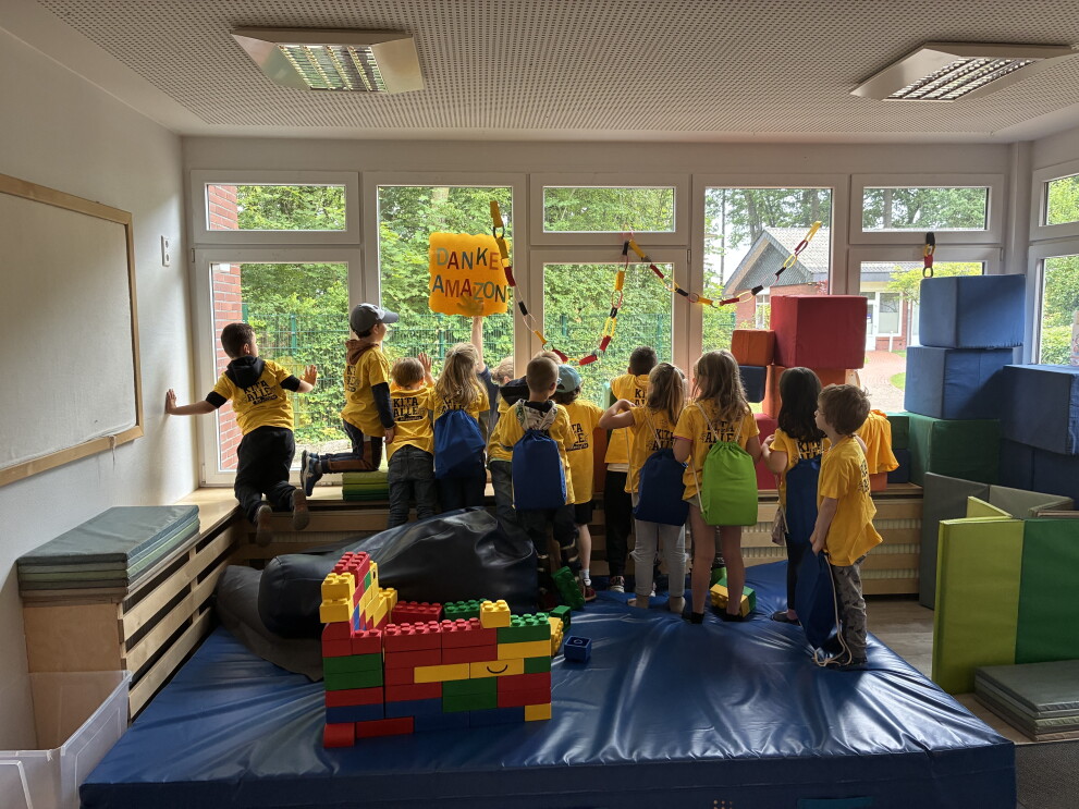Kinder bedanken sich beim Amazon Standort in Cloppenburg für die Spenden von Schulbeuteln