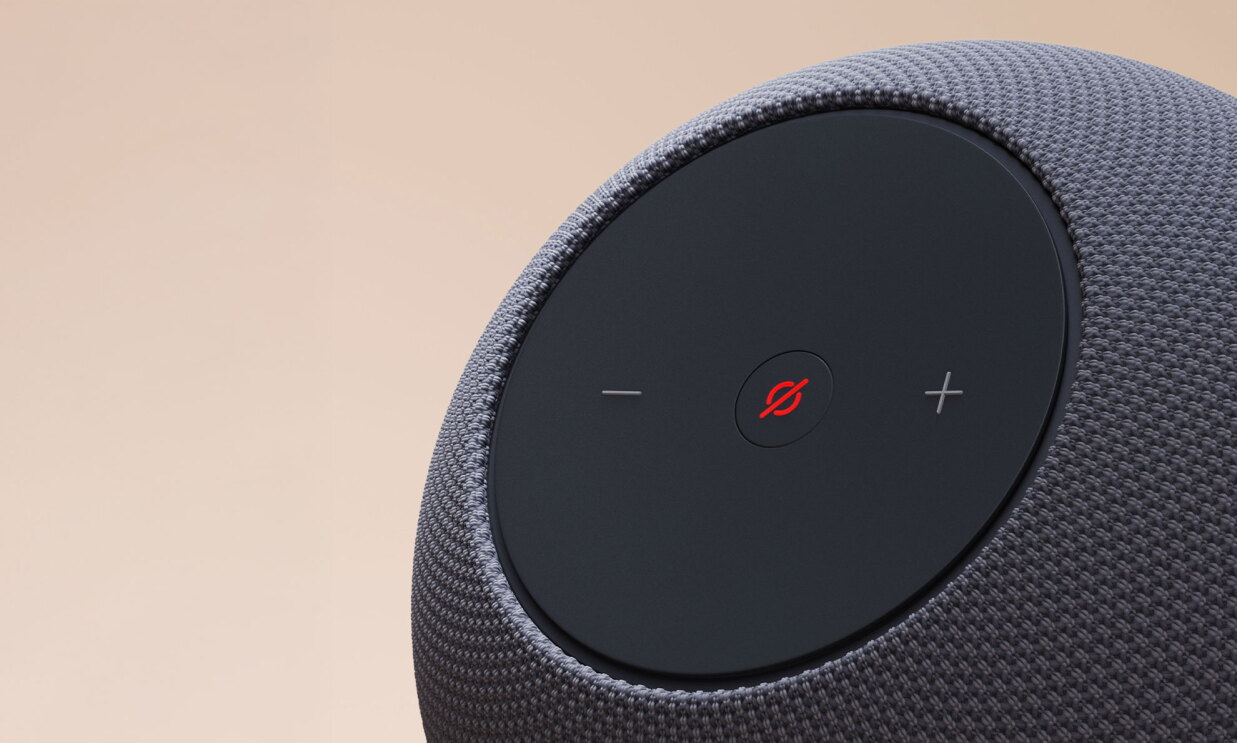 ベージュの背景に、黒い球状デバイスのクローズアップ。前面上側の丸いパネルに「－」と「＋」の記号。パネル中央の斜線入り丸ボタンが赤く点灯している。パネル以外の本体表面はメッシュ状。