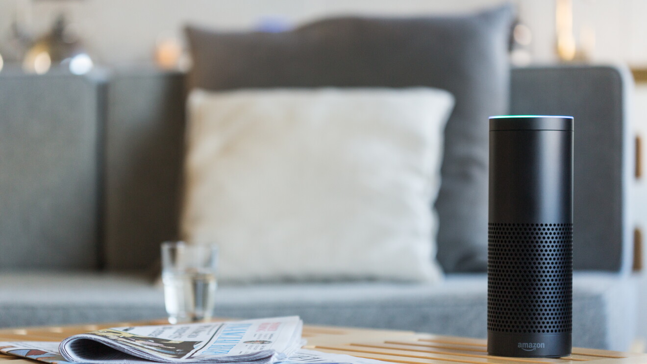 A black Amazon Echo sits on a table. 