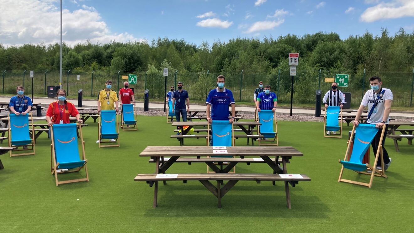 Amazon employees outside the fulfilment centre in Bolton in football shirts socially distanced