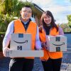 Amazon Flex drivers Chris and Joan Tan holding Amazon packages for delivery.