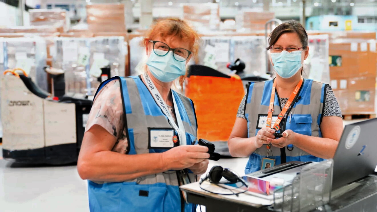 L'immagine mostra due dipendenti in uno dei centri di distribuzione di Amazon