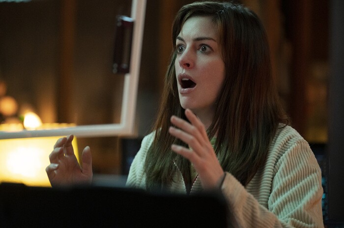 An image of Anne Hathaway looking shocked and surprised with her hands raised in front of her. 